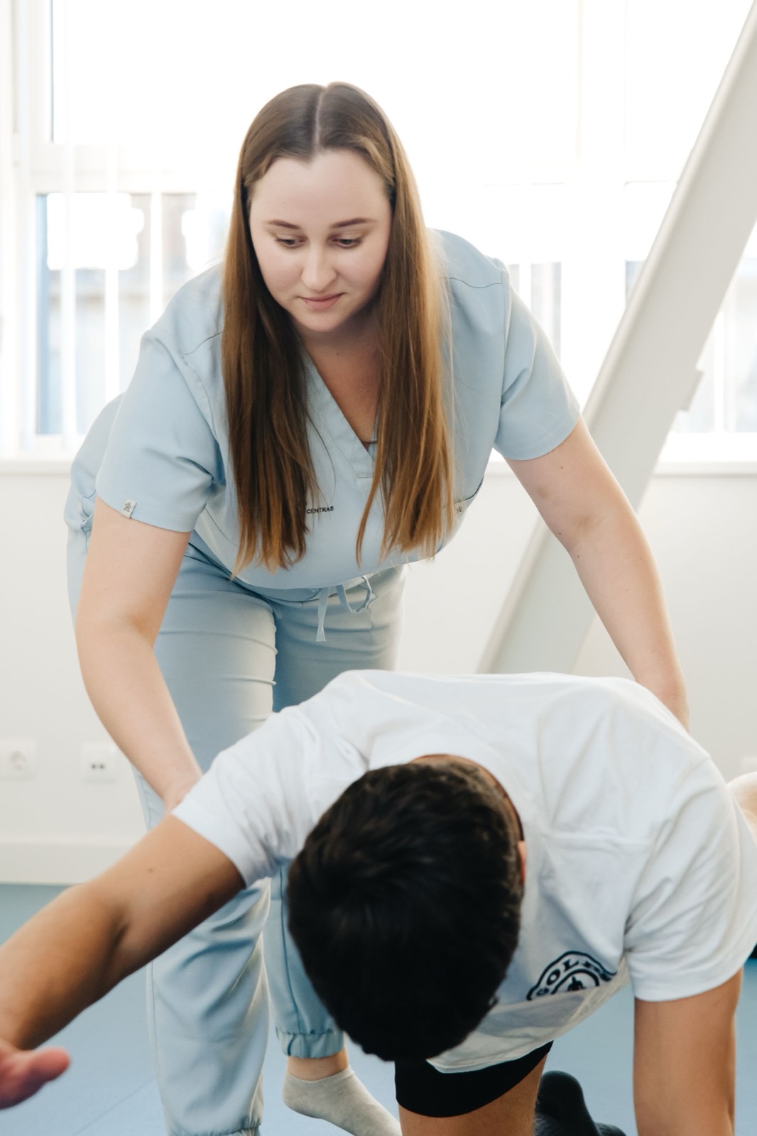 Physiotherapist leaning over a patient during a treatment session